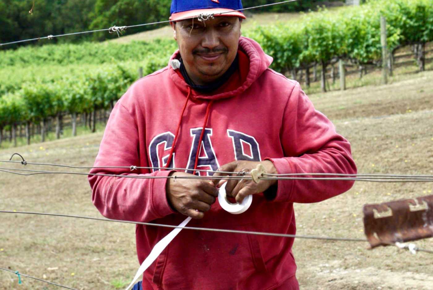 farmworker smiling and holding tape