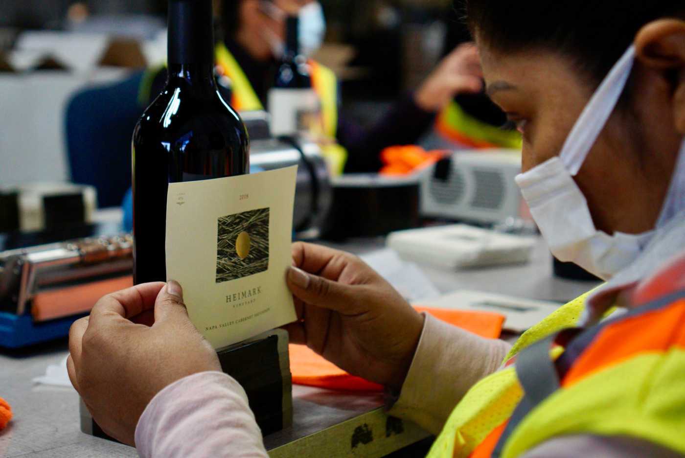 Heimark label being placed on wine bottle